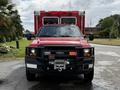 A red 2007 Ford F-550 truck with a front winch and emergency lights on the roof