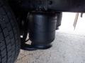 Close-up of the air suspension system featuring black air bags mounted between the chassis and axle of a 2014 International Durastar