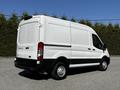 White 2021 Ford Transit van with a high roof and sliding door on the side seen from the rear left angle