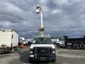 A 2008 Ford Econoline with a bucket lift attachment at the top facing forward