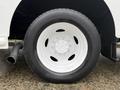 A close-up of a white wheel and tire from a 2018 Ford E-450 with visible tread patterns and a rim featuring multiple lug nut holes