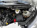 Close-up view of the engine compartment of a 2020 Ford Transit showing various engine components including fluid reservoirs and a battery