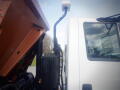 A 2016 International WorkStar 7500 truck with a raised orange dump bed displaying hydraulic lift components and a side view of the cabin