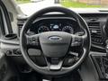 Steering wheel of a 2021 Ford Transit with buttons for controls and the Ford logo in the center