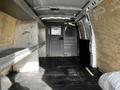 Interior of a 2015 Chevrolet Express van with metal shelving on the sides and a partition at the back separating the driver area from the cargo space