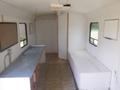 Interior of a 2004 Royal 18 Foot Office Trailer featuring a countertop area a blank wall space and a bench seating area along the side