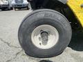 A close-up view of a yellow 1999 Ez-go Industrial tire showing tread pattern and brand name Carlisle on the sidewall