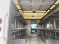 Interior view of a 2012 Ford Econoline with metal shelving and a partition separating the cargo area from the cabin