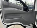 The interior door panel of a 2019 Hino 195 featuring a gray finish with manual window controls and a storage compartment