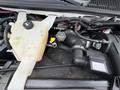 Close-up view of the engine compartment of a 2017 Chevrolet Express showing components like the coolant reservoir and air intake system