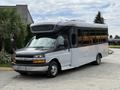A 2019 Chevrolet Express bus with a sleek black and silver exterior features large windows and a spacious design for passenger transport