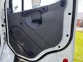 A close-up view of the driver side door of a 2012 Freightliner M2 112 featuring a gray plastic panel with a handle and a textured grip