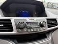View of the dashboard controls of a 2014 Honda Odyssey featuring climate control buttons and a display screen showing a radio station