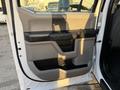 A 2018 Ford F-350 SD door panel showing a beige and black interior design with handles and storage compartments