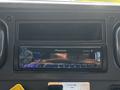 A Pioneer car stereo with a digital display and control buttons mounted in the dashboard of a 2004 Freightliner M2