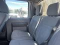 The interior of a 2015 Ford F-550 showcasing the rear seating area with gray fabric upholstery and seatbelts