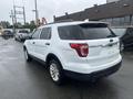 A white 2016 Ford Explorer with a rear view showing its design features including taillights and a chrome accent on the back