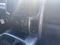 A 2021 RAM 1500 interior dashboard featuring a central touchscreen display with various controls and buttons around it