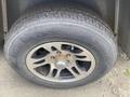 Close-up of a wheel and tire from a 2020 Stealth Enterprises Trailer featuring a five-spoke silver rim and a black rubber tire with visible tread patterns