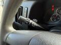 A close-up view of the steering wheel in a 2020 Chevrolet Express showing the turn signal and headlight control stalk