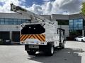 White 2012 Freightliner M2 106 bucket truck with a raised extendable boom and a large storage compartment on the back