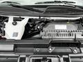 The engine compartment of a 2023 GMC Savana showcasing the engine and various components including hoses and a reservoir