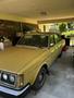A yellow 1978 Volvo 244 parked in a garage with visible dirt and wear on the exterior surface