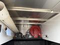 A 2016 RAM 1500 with an interior setup featuring a red hose reel a black air compressor and a large white pipe mounted on the wall