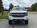 A 2017 Chevrolet Silverado 1500 in white with a chrome grille and large wheels is positioned facing the camera