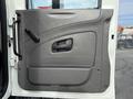 Gray door panel of a 2008 International 4300 with a handle and a small window opening