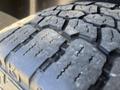 Close-up of a rugged tire tread on a 2011 RAM 1500 showing deep grooves for traction and wear patterns on the rubber surface