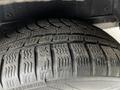 Close-up of a worn tire tread on a 2014 Ford Transit Connect showing various patterns and grooves designed for traction