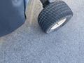 A close-up view of a tire from a 2010 Kubota F3680 with a rugged tread pattern and a light-colored rim
