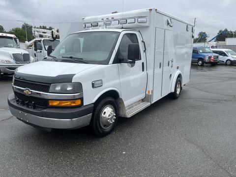 A 2016 Chevrolet Express van designed as an ambulance with a white exterior and light bar on top