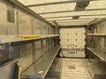 2012 Ford Econoline interior showing metal shelving units along the sides and a closed rear door