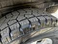 Close-up of a textured tire with deep treads showing wear and grip patterns typical of a durable off-road tire designed for a 2003 Mitsubishi Delica