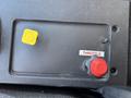 A control panel with a red throttle knob and a yellow indicator on a black surface