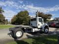 A white 2003 Freightliner M2 106 truck is positioned with its chassis visible and no cargo box attached