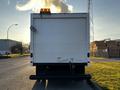 A white 2017 Ford Econoline van with a amber light on top and a hitch at the rear