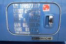 A blue 2015 Kenworth T660 truck with a metallic identification plate displaying various specifications and a door handle
