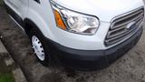 A white 2018 Ford Transit van showing the front left side with a clear view of the headlight and grille