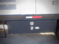 A 2007 Ford F-650 with a dark storage compartment featuring a lock and a classic logo on the side