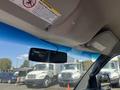 Interior view of a 2012 Chevrolet Express showing the rearview mirror and overhead compartments with a blue sky visible through the windshield