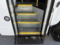 A close-up view of the staircase leading inside a 2022 Blue Bird Vision bus featuring metal steps with yellow safety markings
