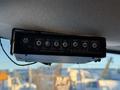 A control panel with various buttons including power enable dim cargo auxiliary left warn and right functions mounted in a vehicle