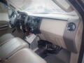 Interior view of a 2008 Ford F-550 featuring a gray dashboard with controls and a black floor mat showing two front seats and an automatic gear shift