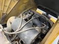 A close-up view of the engine compartment of a 2011 John Deere 310SJ 4x4 Wheel Loader showing the air intake and hose connections with visible dirt and dust on the components
