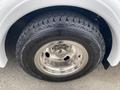 A close-up of a Goodyear Wrangler tire mounted on a shiny chrome rim with visible tread patterns