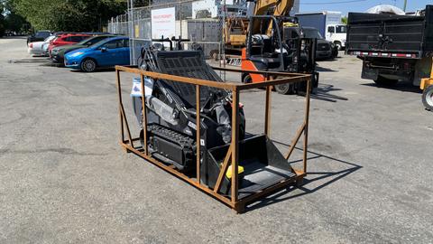 2024 Agt Ktt23 Stand On Skid Steer Track Loader 23HP with a black and grey body and a front bucket is secured within a wooden frame