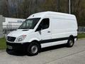 A white 2012 Mercedes-Benz Sprinter van with a sleek design and black accents parked on a concrete surface